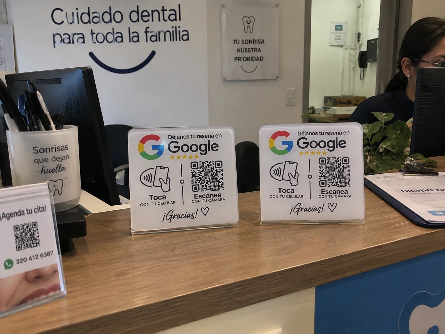 Dos placas NFC y QR ubicadas en la recepción de una clínica odontológica